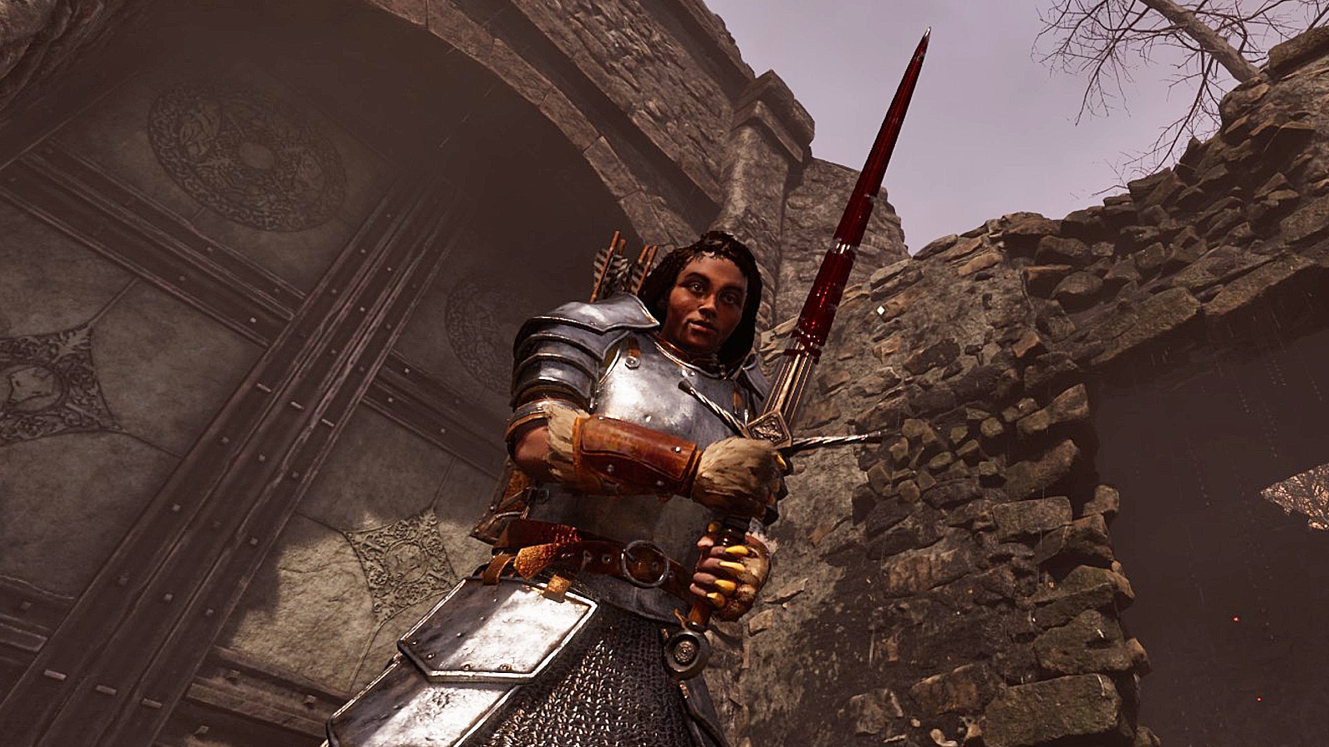 A female character in armor holds a blood-stained sword against a rocky battlefield in The Elder Scrolls IV: Oblivion Remastered.