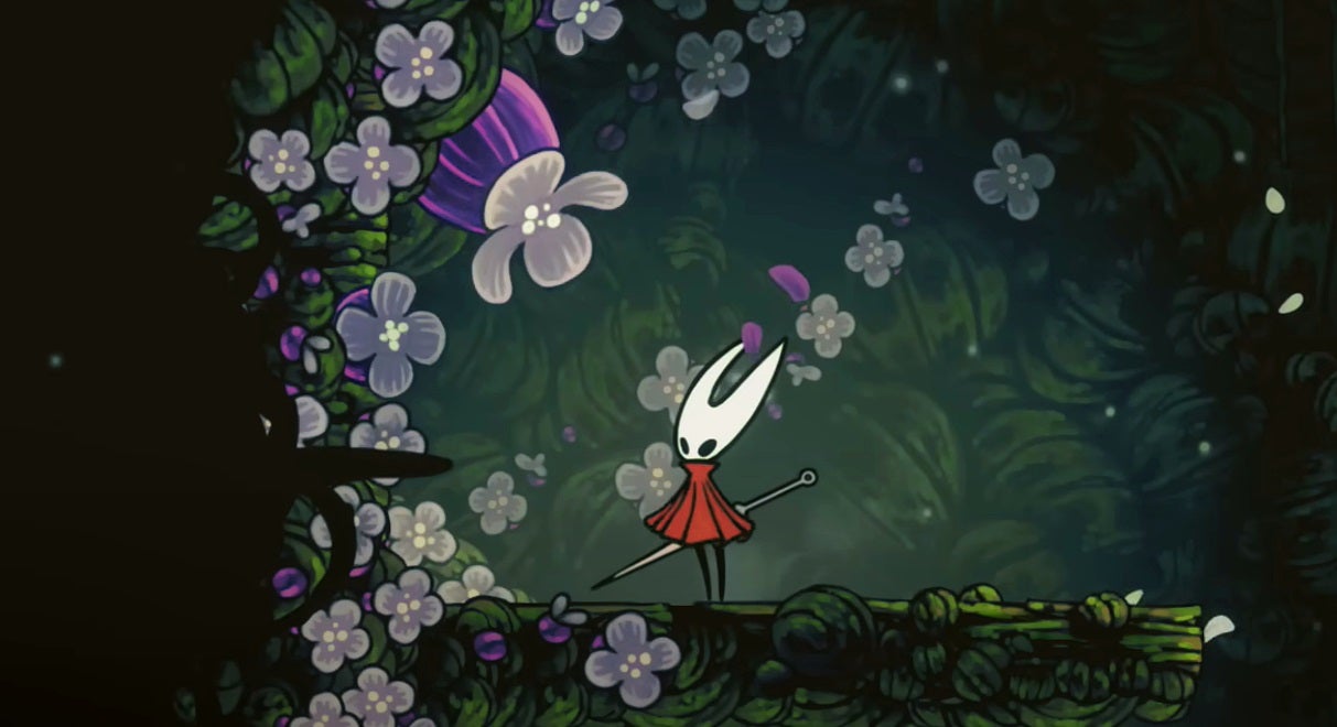 Hornet stands next to a purple flower that contains a Pollip Heart, in Hollow Knight: Silksong.